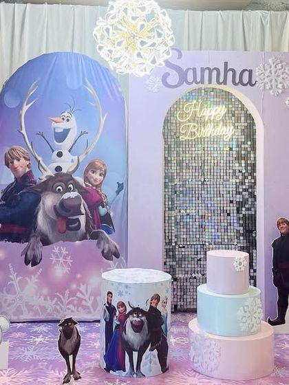 A magical Frozen-themed birthday party for Samha. We created a winter wonderland with character backdrops of Elsa, Anna, and Olaf, a shimmering sequin archway, and a light-up number '5'.