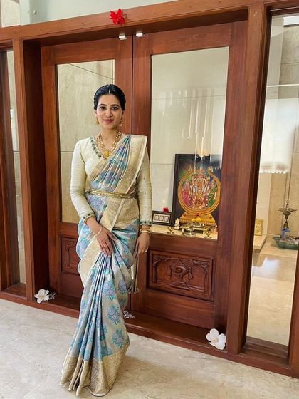 Here, Keerthana's daughter wears a beautiful silver-blue floral brocade saree, showing how our sarees are loved across generations.