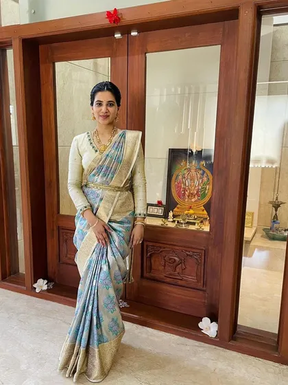 Here, Keerthana's daughter wears a beautiful silver-blue floral brocade saree, showing how our sarees are loved across generations.