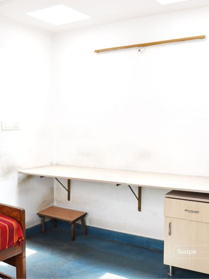 A simple and functional study or bedroom space, with a floating desk and a bed. The skylight provides ample natural light for working or reading.