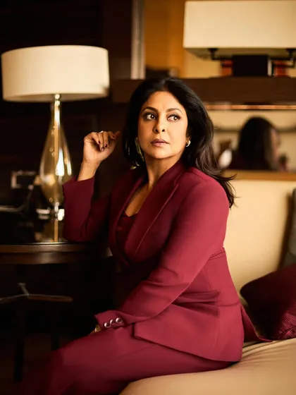 Seated in a lounge, this image exudes quiet confidence, with the rich color of the suit standing out.