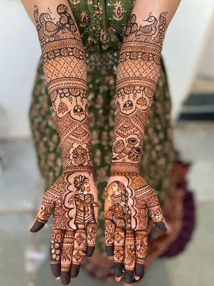 A clear, straight-on view of the beautiful portrait mehandi, showcasing the symmetry and detailed patterns that extend up to the elbows.