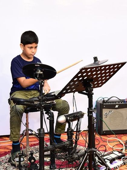 A young drummer takes the stage at our student concert. Performing live is a crucial part of our teaching method, helping students build confidence and stage presence.