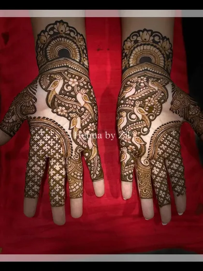 The same design in color, showing the fresh henna paste against a red background.