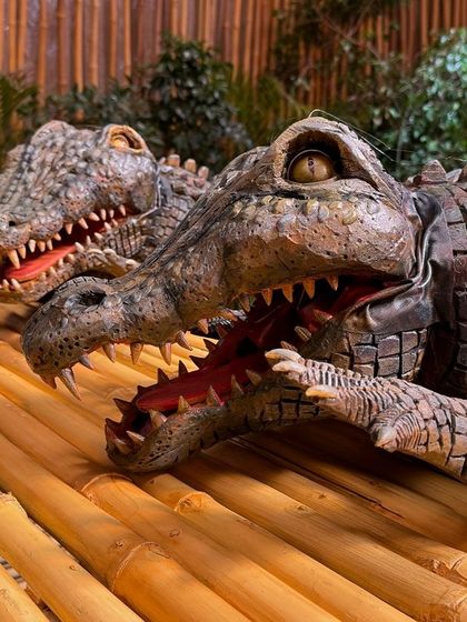 The two crocodile puppets on the bamboo set, ready for their scene. We built them to be durable and expressive, capable of a wide range of movements needed for the promo.