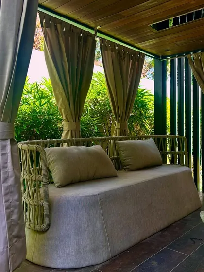 This private gazebo in Jaipur, draped with curtains, offers a shaded and secluded seating area. It’s a perfect example of creating a comfortable outdoor room within a larger garden.