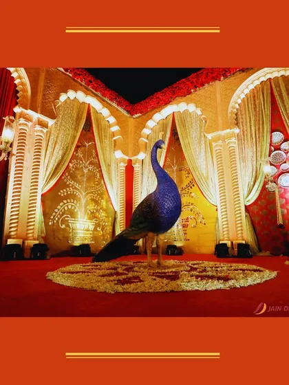 A majestic peacock statue stands in the center of a royal-themed event space. This bold and beautiful prop adds a touch of Indian regality to the decor.