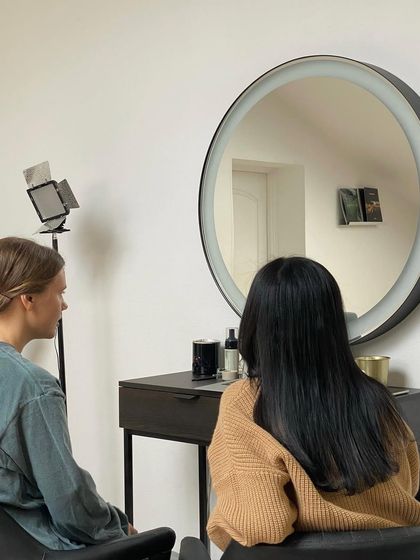 The consultation is a critical first step. Here, an instructor and student discuss the client's goals before beginning the service, a key part of our training curriculum.