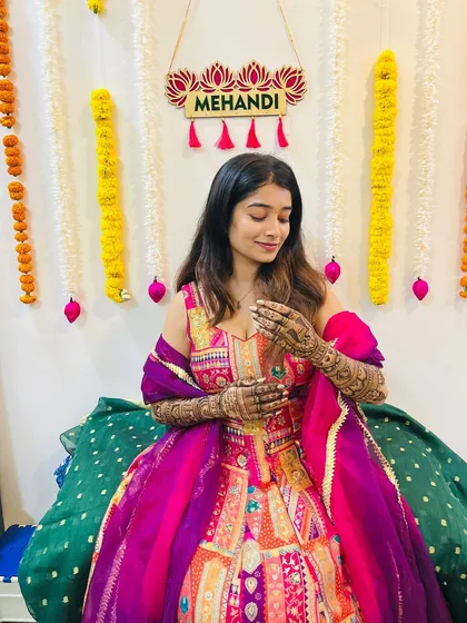 Shrutika admiring her freshly applied mehendi. The joy and anticipation of the wedding day are palpable.