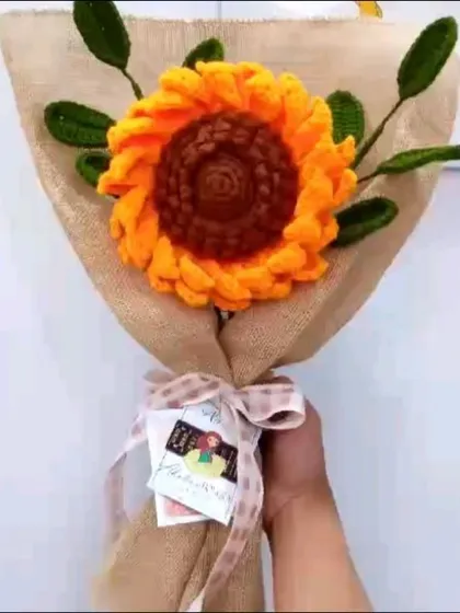 Here is a large, single statement sunflower bouquet I created. The bright yellow petals and detailed brown center are complemented by crocheted green leaves and a rustic burlap wrap, tied with a simple ribbon.