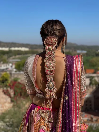 For this Mehndi look, I designed an intricate statement braid and adorned it with a stunning, oversized traditional hair accessory. This style is not only beautiful from the back but also practical for a long event.