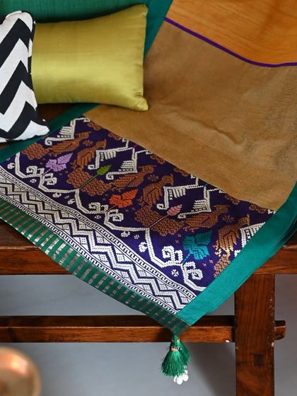 The runner draped on a modern bench, showing how traditional textiles can be incorporated into contemporary decor.