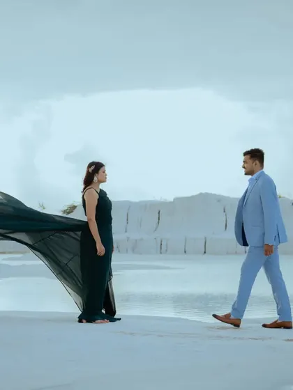 A dynamic "first look" style shot, with the groom walking towards the bride. The movement in her gown adds a sense of anticipation and romance to this pre-wedding photo.