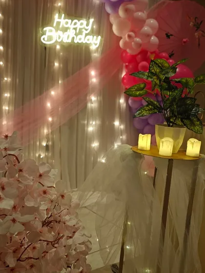 A corner detail from the 12th birthday setup, showing the cherry blossom arrangement and the warm glow of the fairy lights and candles.