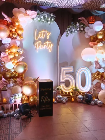 Celebrating a 50th birthday in style! This elegant setup features a 'Let's Party' neon sign, a sophisticated rose gold and white balloon arch, and large light-up marquee numbers. I also added personalized photo cubes to display cherished memories, making the celebration deeply personal.