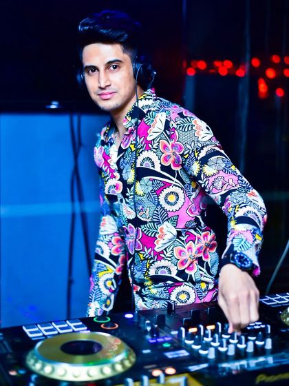 Spinning live at Drava Lounge. My floral shirt matches the vibrant Bollywood beats I'm playing.