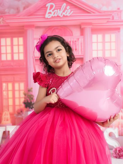 Pretty in pink for her Barbie-themed photoshoot. Her sweet smile and beautiful dress make this a picture-perfect moment.