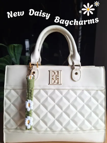 A shot of our new daisy bag charms, showing how a small, handmade accessory can instantly elevate your style.
