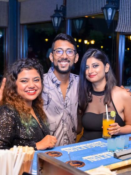 Friends posing for a photo at the bar during a karaoke night. It's all about good music, good company, and good times.