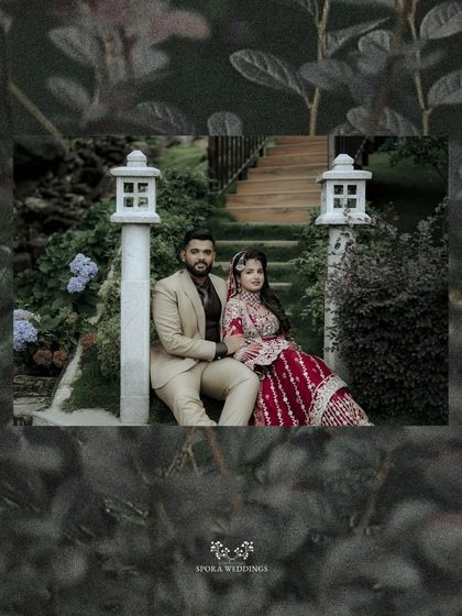 A serene portrait of the couple seated in a garden, framed by lush greenery and soft light.