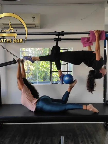 Partner workouts on the Cadillac are a fantastic way to build trust and challenge your stability. This exercise requires complete coordination and showcases the fun, collaborative spirit of our studio.