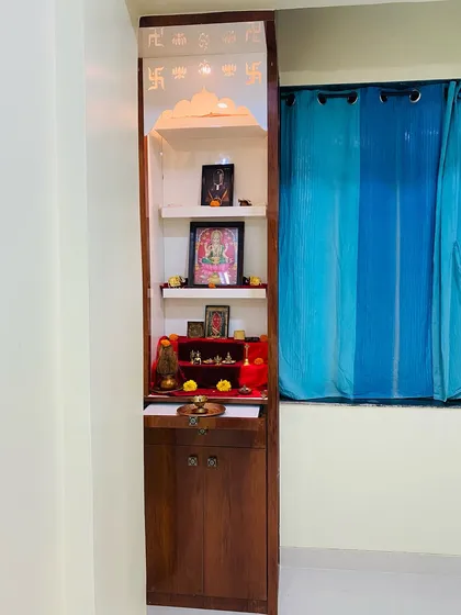 The bedroom mandir shown with its doors closed, appearing as an elegant, slim cabinet.