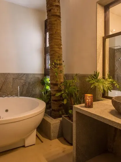 We believe in creating sanctuary-like personal spaces. This bathroom blurs the line between indoors and outdoors, incorporating a live tree and natural stone to create a spa-like retreat that is connected to nature.