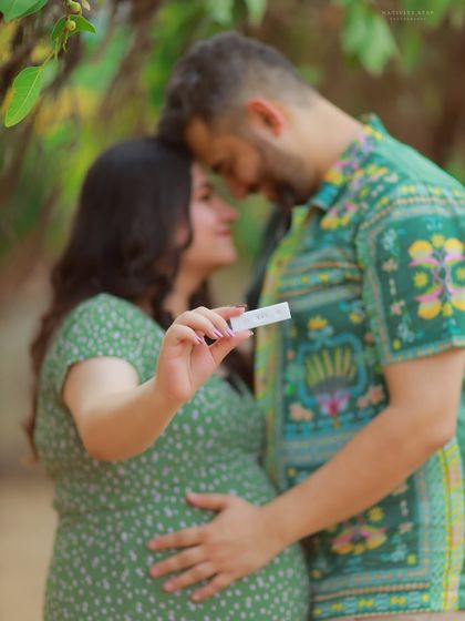 A creative shot focusing on the positive pregnancy test, with the happy couple in the background. This image tells the story from the very beginning.