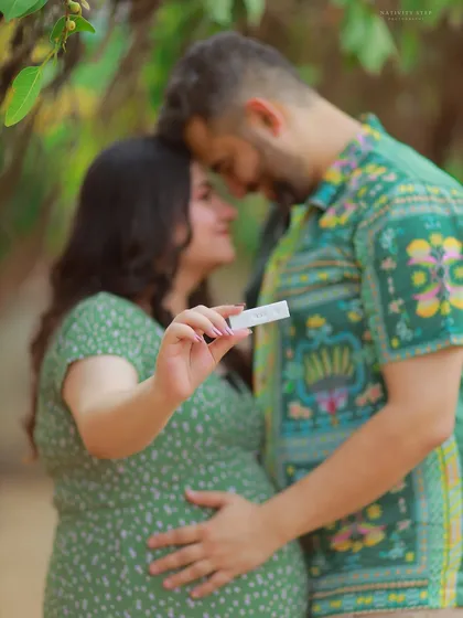 A creative shot focusing on the positive pregnancy test, with the happy couple in the background. This image tells the story from the very beginning.