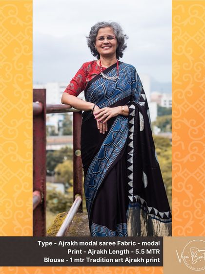 A full-length view of our black Ajrakh modal saree with striking blue geometric prints. The golden zari border adds a touch of festive shimmer to this artisanal piece.