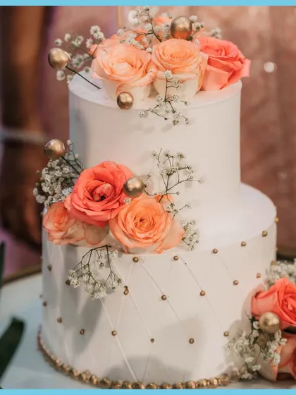 A slice of love. The beautiful two-tiered cake for the engagement ceremony, adorned with fresh roses.