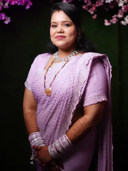 A beautiful wedding guest in a lavender saree, with soft glam makeup perfect for the occasion.