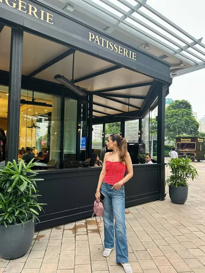 A side profile of my red top and jeans outfit. Tying my hair in a high ponytail keeps the look fresh and casual.
