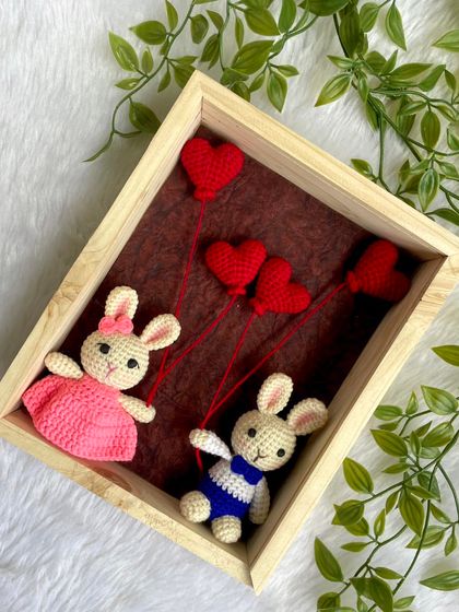 A sweet bunny couple floating with heart balloons, all captured within a beautiful wooden frame. This makes for a whimsical and romantic keepsake.