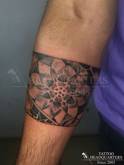 A wide armband featuring a detailed mandala pattern, demonstrating our skill in dotwork and geometric precision.