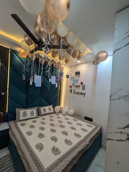 A wider view of the bedroom, showing how the balloon and photo decorations create a beautiful canopy effect over the bed.