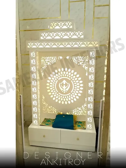 Another example of a custom mandir with 'Ek Onkar' jali work, this one featuring drawers for storage.