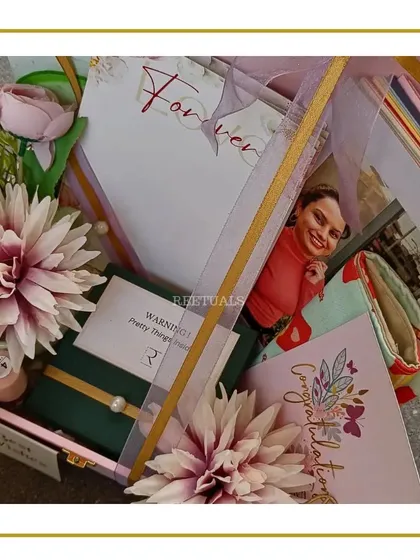 Another view of the pink trunk box for an engagement, showing the photo, "Forever" card, and other curated items.