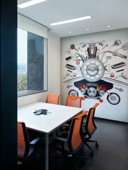 A meeting room at the Harley-Davidson office features a dynamic wall mural composed of motorcycle parts and illustrations. This brand-driven interior detail turns a functional space into an inspiring one that reinforces the company's identity.
