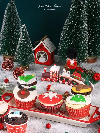 Another angle of the festive Christmas cupcakes, arranged on a cute sleigh-shaped platter. This adds another layer of holiday cheer to the composition.