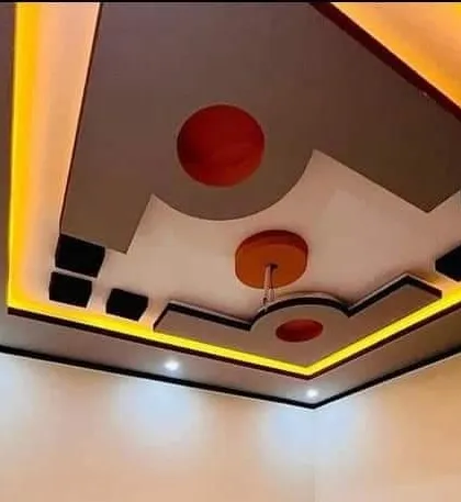 A compact design for a smaller room, using warm yellow cove lighting and a pop of red. This shows that even small spaces can have a stylish ceiling.