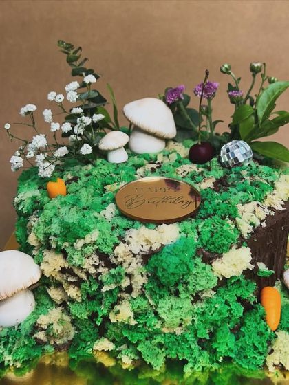 A still shot of the whimsical forest floor cake. The combination of green cake moss, mushrooms, and a hidden disco ball makes it a truly unique and imaginative creation.