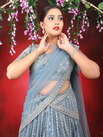 A high-fashion party look featuring a bold red lip and a dramatic silver-blue cut crease eyeshadow.