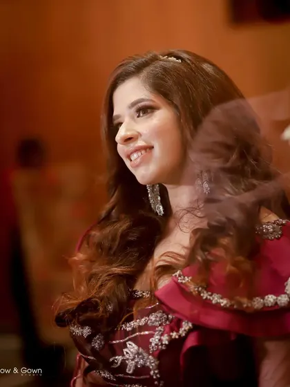 A candid shot capturing the bride's natural smile and happiness during her engagement. The soft focus and warm lighting highlight her joy in this unposed, beautiful moment.