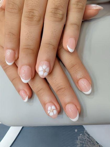 When you want something timeless yet playful. This classic French manicure gets a fresh update with delicate, hand-painted floral accent nails.
