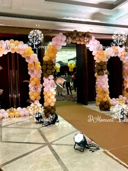 A grand entrance for a twins' first birthday with a Boho Rainbow theme. Multiple balloon arches in earthy and pastel tones create a warm and inviting tunnel for guests to walk through.