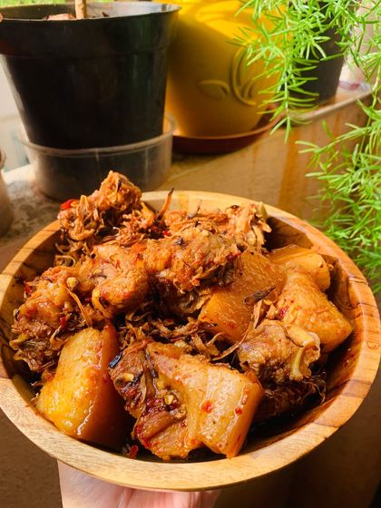 My pork with dried bamboo shoot, served in a wooden bowl. The background shows my little kitchen garden.