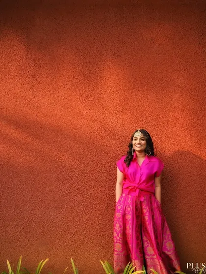 A smiling bride against a simple, textured orange wall, showing that great photos can be found in the simplest of settings.