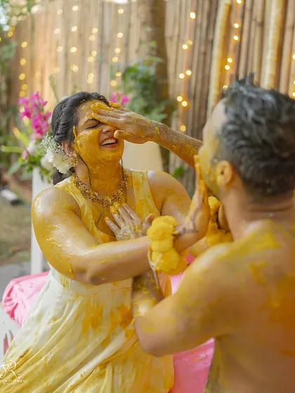 The groom playfully applying haldi to his bride. This ceremony is all about love, blessings, and a lot of fun.