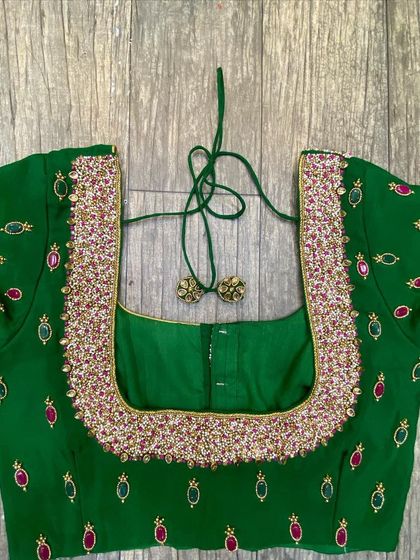 This green blouse has a heavily beaded neckline. The rest of the blouse has scattered motifs made with green and red stones.